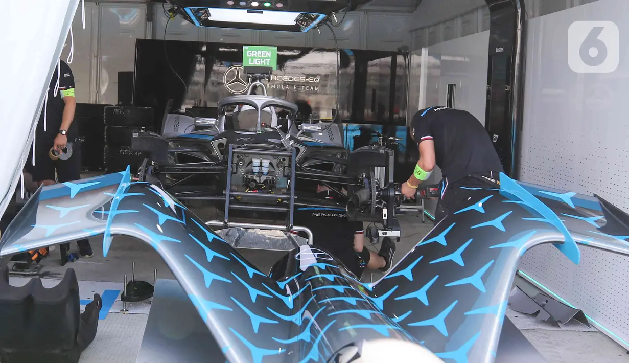 Kru tim peserta lomba balap melakukan persiapan mobil listrik Formula E  di pit Jakarta International E-Prix Circuit (JIEC), Jakarta, Jumat (3/6/2022). Menjelang pertandingan Formula E pada besok hari (4/6/2022) kru tim pembalap melakukan persiapan mobil listrik Formula E. (Liputan6.com/Herman Zakharia)