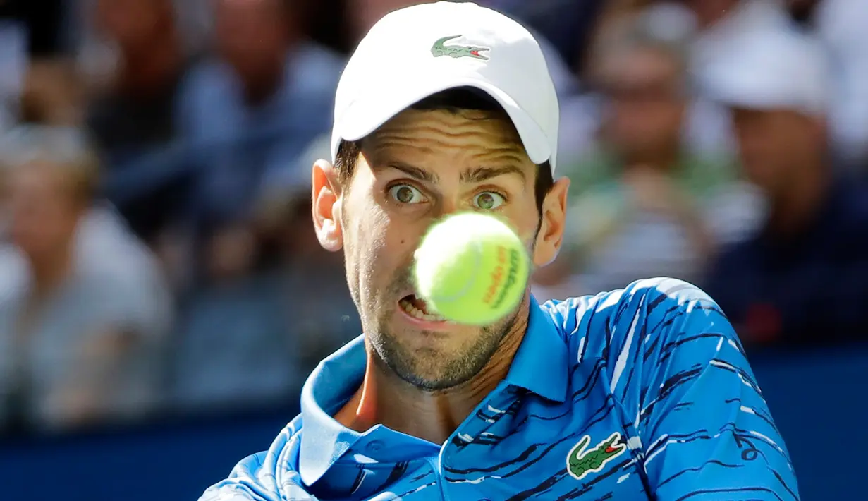 Petenis Serbia, Novak Djokovic  mencoba mengembalikan bola ke arah lawannya Roberto Carballes Baena dari Spanyol pada  babak pertama AS Terbuka 2019 di Billie Jean King National Tennis Center, New York, Senin (26/8/2019). Unggulan pertama itu memetik kemenangan 6-4, 6-1, 6-4. (AP/Frank Franklin II)