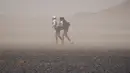 Perjuangan dua peserta melintasi gurun Sahara dalam kejuaraan marathon des Sables di Maroko Selatan, (10/4). Marathon des Sables kali ini merupakan gelaran yang ke-31. (AFP PHOTO/JEAN-PHILIPPE Ksiazek)