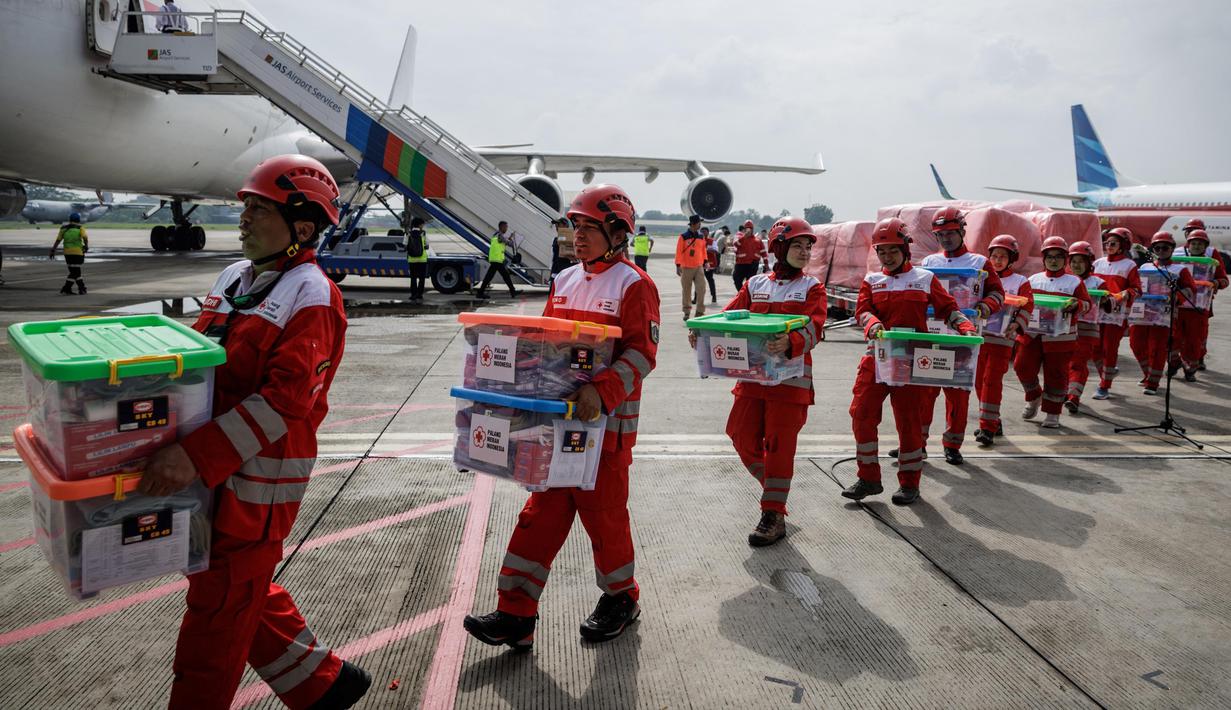 Personel Palang Merah Indonesia (PMI) membawa kotak-kotak berisi bahan bantuan setelah upacara keberangkatan misi bantuan kemanusiaan Indonesia ke Myanmar di Pangkalan Udara Halim Perdanakusuma, Jakarta, 3 April 2025. (YASUYOSHI CHIBA/AFP)