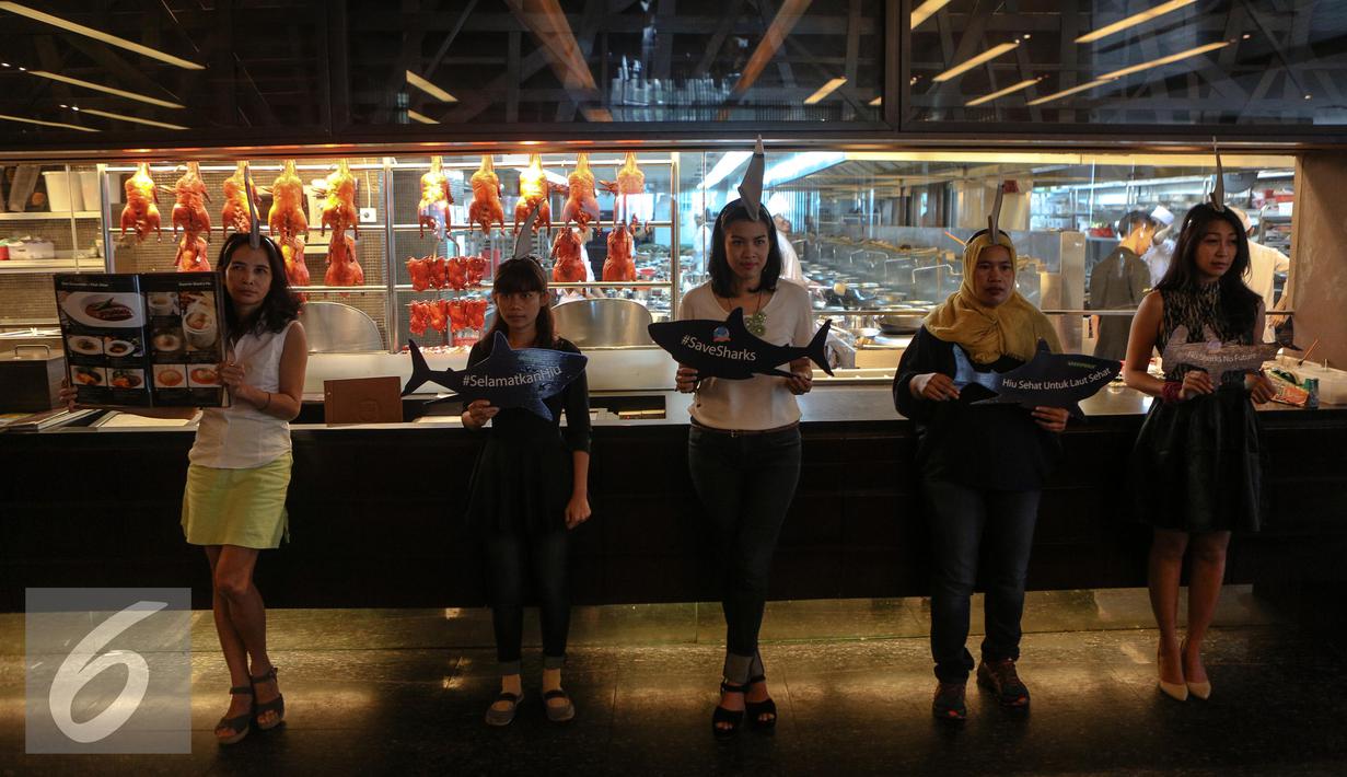 Sejumlah aktivis Greenpeace Indonesia menggelar kampanye selamatkan hiu (savesharks) di salah satu rumah makan, Jakarta, Minggu (12/7/2015). Aksi tersebut sebagai upaya menyelamatkan hiu dari kepunahan. (Liputan6.com/Faizal Fanani)