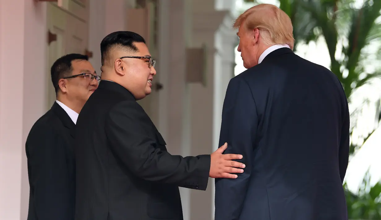 Pemimpin Korea Utara, Kim Jong-un bertemu dengan Presiden AS, Donald Trump di resor Capella, Pulau Sentosa, Singapura, Selasa (12/6). Pertemuan ini merupakan yang pertama kalinya bagi pemimpin AS dan Korut untuk bertatap muka. (SAUL LOEB/AFP)