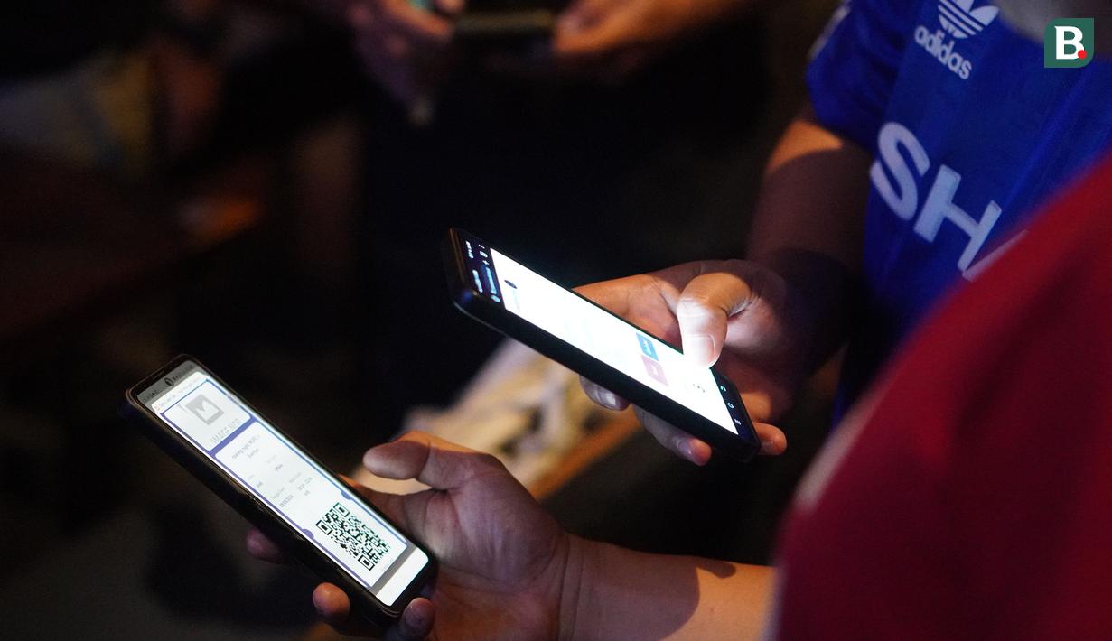Pengunjung melakukan scan barcode registrasi Roaring Night pertandingan Liga Inggris 2023/2024 antara Manchester United versus Everton di Brewerkz, The Breeze BSD City, Tangerang, Sabtu (9/3/2024) malam WIB. (Bola.com/Afi)