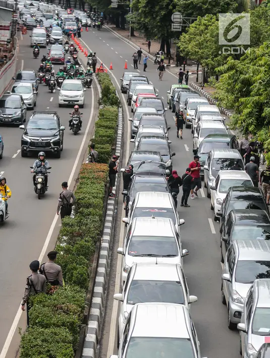 Sejumlah mobil pengemudi online menutup jalur lambat saat mereka menggelar demo di kantor pusat Grab kawasan Kuningan, Jakarta, Senin (29/10). Akibat aksi tersebut, kemacaten parah terjadi dari arah Mampang menuju Menteng. (Liputan6.com/Faizal Fanani)