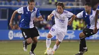 Gelandang Deportivo Alaves  Tomas Pina (kiri) bersaing dengan gelandang Real Madrid Luka Modric pada partai perdana La Liga Spanyol musim 2020/2021 di Estadio de Mendizorroza, Minggu dini hari WIB (15/8/2021). Real Madrid menang telak 4-1. (Josep LAGO / AFP)