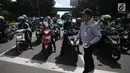 Sejumlah pengendara motor menerima selebaran sosialisasi lajur khusus sepeda motor di Jalan MH Thamrin, Jakarta, Senin (29/1). (Liputan6.com/Arya Manggala)