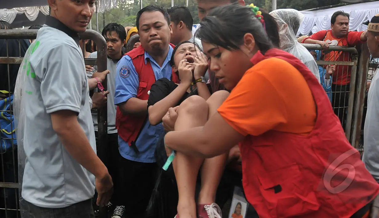 Sejumlah wanita pingsan saat mengantre untuk menonton konser One Direction, Senayan, Jakarta, Rabu (25/3/2015). Puluhan ribu orang rela mengantre untuk melihat konser One Direction. (Liputan6.com/Johan Tallo)
