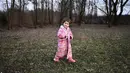 Seorang gadis muda mengenakan jubah saat melewati halaman belakang sebuah rumah bagi mereka yang melarikan diri dari Ukraina, di desa Uszka, Hungaria, 3 Maret 2022. PBB pada Kamis (3/3) melaporkan 1 juta orang telah meninggalkan Ukraina sejak invasi Rusia sepekan lalu. (AP Photo/Anna Szilagyi)