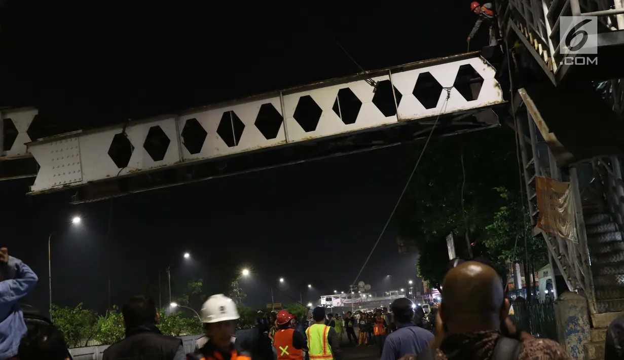 Pekerja berusaha menurunkan potongan rangka utama Jembatan Penyeberangan Orang Pasar Minggu, Jakarta, Sabtu (6/4). Proses pembongkaran JPO Pasar Minggu ini akan berlangsung hingga 7 April mendatang. (Liputan6.com/Helmi Fithriansyah)