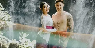 Millen Cyrus dan kekasihnya tampil dengan busana adat Bali. Millen dengan kebaya putih, dipadu dengan kain batik bernuansa ungu, dan selendang ungu. Sedangkan kekasihnya bertelanjang dada dengan kain bernuansa merah keemasan dan selendangnya. Foto: Instagram.