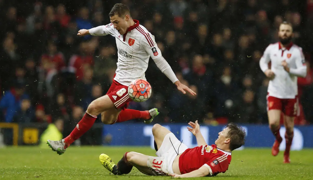 Pemain Manchester United, Bastian Schweinsteiger  melakukan tackle saat berebut bola dengan pemain Sheffield United, Paul Coutts pada laga Piala FA di Old Trafford, Minggu (10/1/2016) dini hari WIB. (Reuters/Phil Noble)