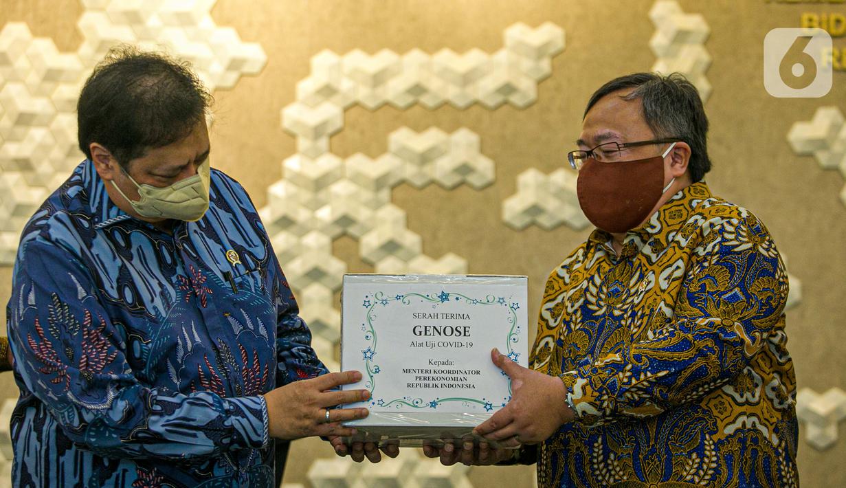 Menristek Bambang Brodjonegoro (kanan) memberikan GeNose C19 kepada Menko Bidang Perekonomian Airlangga Hartarto di Gedung Kemenko Perekonomian, Jakarta, Senin (22/3/2021). GeNose C19 diharapkan dapat semakin dikenal dan dimanfaatkan secara lebih masif. (Liputan6.com/Faizal Fanani)