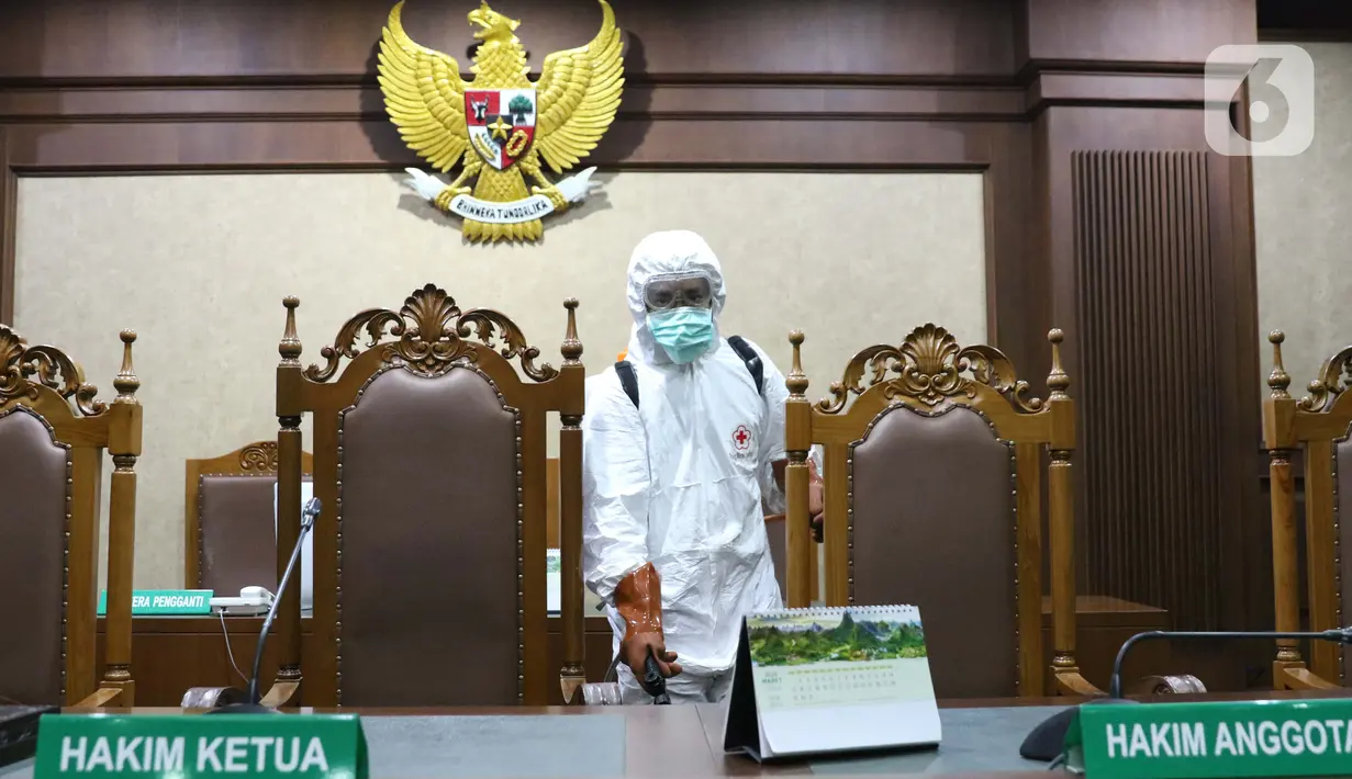 Petugas Palang Merah Indonesia saat melakukan penyemprotan cairan disinfektan di salah satu ruang sidang Pengadilan Negeri Jakarta Pusat, Rabu (18/3/2020). Penyemprotan cairan disinfektan untuk mencegah penyebaran virus corona COVID-19. (Liputan6.com/Helmi Fithriansyah)