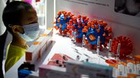 Seorang anak melihat kandidat vaksin Covid-19 dari Sinovac Biotech LTD yang diperlihatkan dalam Pameran Internasional China untuk Perdagangan Jasa (CIFTIS) di Beijing pada 6 September 2020. Untuk pertama kalinya, China akhirnya resmi memamerkan produk dalam negeri vaksin COVID-19. (NOEL CELIS/AFP)