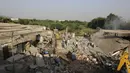 Orang-orang berdiri di lokasi kebakaran di sebuah pabrik di kawasan industri di pinggiran Ahmedabad, India (4/11/2020). Menurut pejabat setempat, puluhan orang tewas ketika sebagian gudang bahan kimia runtuh setelah terjadi ledakan dahsyat. (AP Photo/Ajit Solanki)