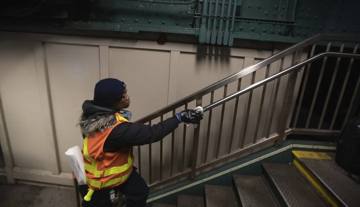 Pekerja Otoritas Transportasi Metropolitan S. Williams membersihkan tiang di stasiun kereta bawah tanah Avenue X, Selasa (3/3/2020). Mewabahnya penyebaran virus corona di New York membuat ruang publik seperti stasiun kereta melakukan pembersihan guna mencegah penyebaran virus. (AP Photo/Kevin Hagen)