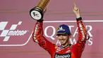 Pembalap Ducati Lenovo Team, Francesco Bagnaia saat merayakan gelar juara di podium MotoGP Qatar di Sirkuit Internasional Lusail, Doha pada 10 Maret 2024. (KARIM JAAFAR/AFP)