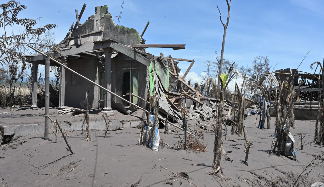 Rumah-rumah rusak yang diselimuti abu vulkanik erupsi Gunung Semeru terlihat di Desa Curah Kobokan, Lumajang, Jawa Timur, Selasa (7/12/2021). Desa yang berada sekitar 15 km dari Lereng Semeru tersebut menjadi desa paling parah yang terkena dampak letusan Gunung Semeru. (ADEK BERRY/AFP)