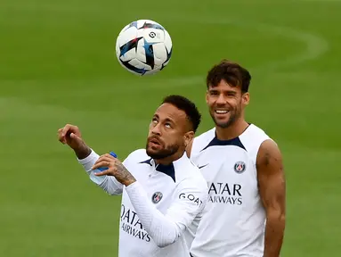 Penyerang Paris Saint-Germain (PSG) Neymar mengontrol bola, di depan Juan Bernat selama sesi latihan jelang melawan Monaco, di Saint-Germain-en-Laye, barat Paris pada 26 Agustus 2022. Laga PSG vs AS Monaco di lanjutan Ligue 1 Prancis akan berlangsung pada 29 Agustus 2022 dinihari WIB. (FRANCK FIFE / AFP)