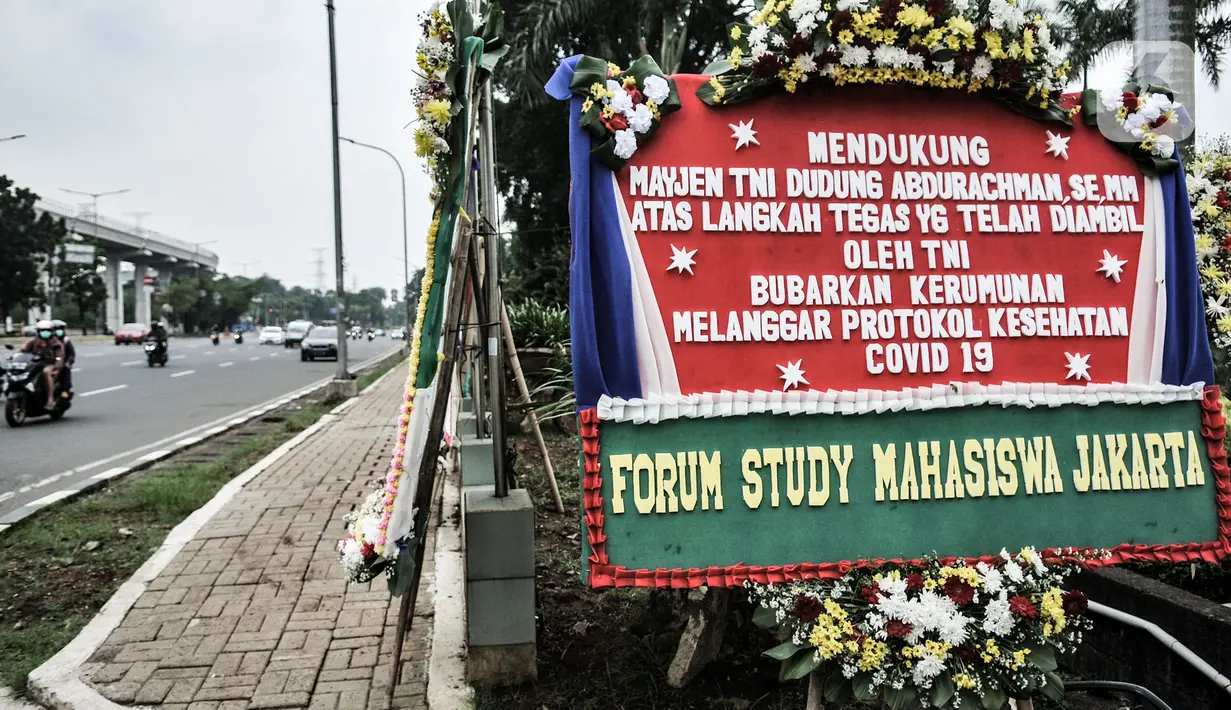 Kendaraan melintasi deretan karangan bunga yang dipajang di depan Markas Kodam Jaya, Jakarta, Senin (23/11/2020). Ratusan karangan bunga dikirim masyarakat sebagai bentuk dukungan terhadap TNI dan Polri atas tindakan tegas kepada pelanggar protokol kesehtan Covid-19. (merdeka.com/Iqbal S Nugroho)