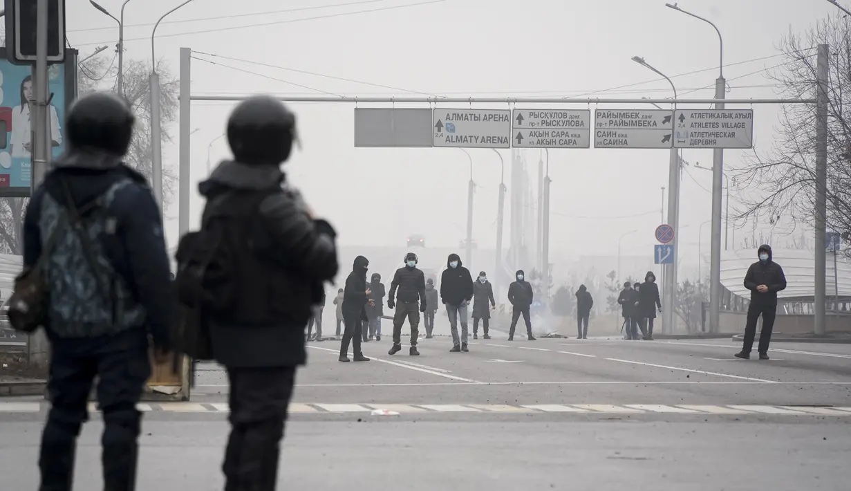 Demonstran berkumpul di depan garis polisi selama protes di Almaty, Kazakhstan, Rabu (5/2/2022). Demonstran yang menolak kenaikan harga gas cair bentrok dengan polisi di kota terbesar Kazakhstan dan mengadakan protes di sekitar kota. (AP Photo/Vladimir Tretyakov)