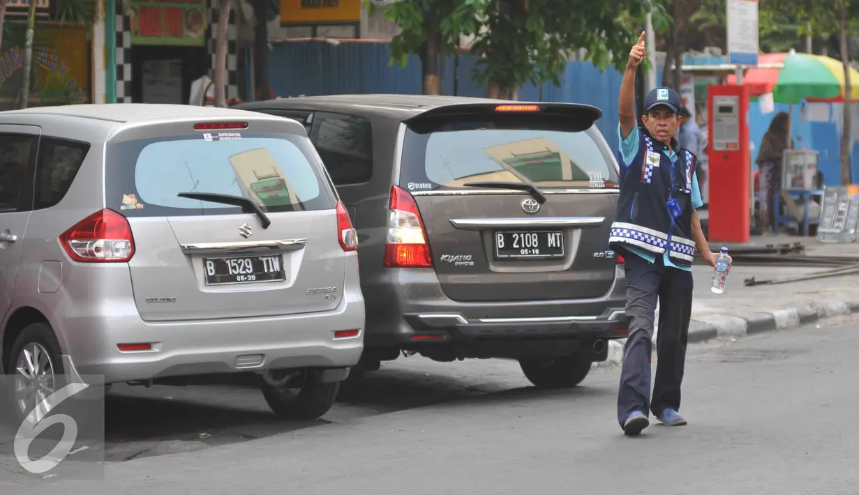 Petugas parkir memakirkan mobil di Jalan Sabang, Jakarta, Senin (21/9/2015). Sesuai janji Unit Pengelola Perparkiran Dishub mereka akan diberi gaji mencapai dua kali upah minimum provinsi (UMP). (Liputan6.com/Gempur M Surya)