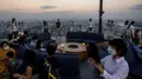 Orang-orang memandangi cakrawala dari dek observasi di gedung pencakar langit King Power Mahanakhon saat matahari terbenam di Bangkok, pada 25 Oktober 2021. Dari ketinggian 314 meter, para pengunjung dapat melihat pemandangan ibu kota Thailand. (Jack TAYLOR / AFP)