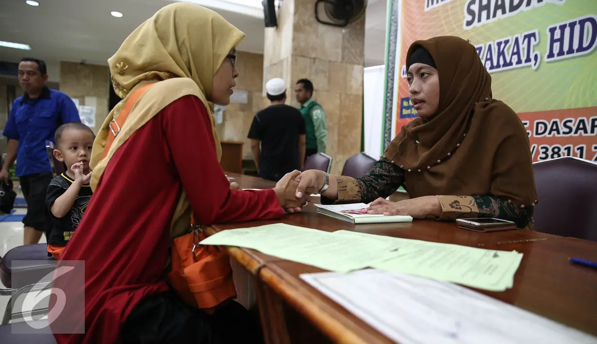 Petugas zakat melakukan ijab kabul penerimaan zakat di di Masjid Istiqlal, Jakarta, Jumat (1/7). Pembayaran zakat berupa beras 3,5 liter atau 2,7 kg atau uang senilai Rp 50 ribu untuk kelas A dan Rp 45 ribu untuk kelas B. (Liputan6.com/Faizal Fanani)
