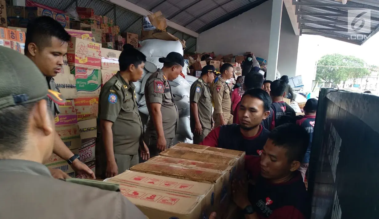Relawan AGP dibantu petugas Satpol PP menyalurkan bantuan untuk pengungsi imbas tsunami Selat Sunda di Rajabasa, Lampung Selatan, Kamis (27/12). Bantuan logistik ini disalurkan untuk 4.000 pengungsi atau sekitar 500 KK. (Liputan6.com/HO/Rini)