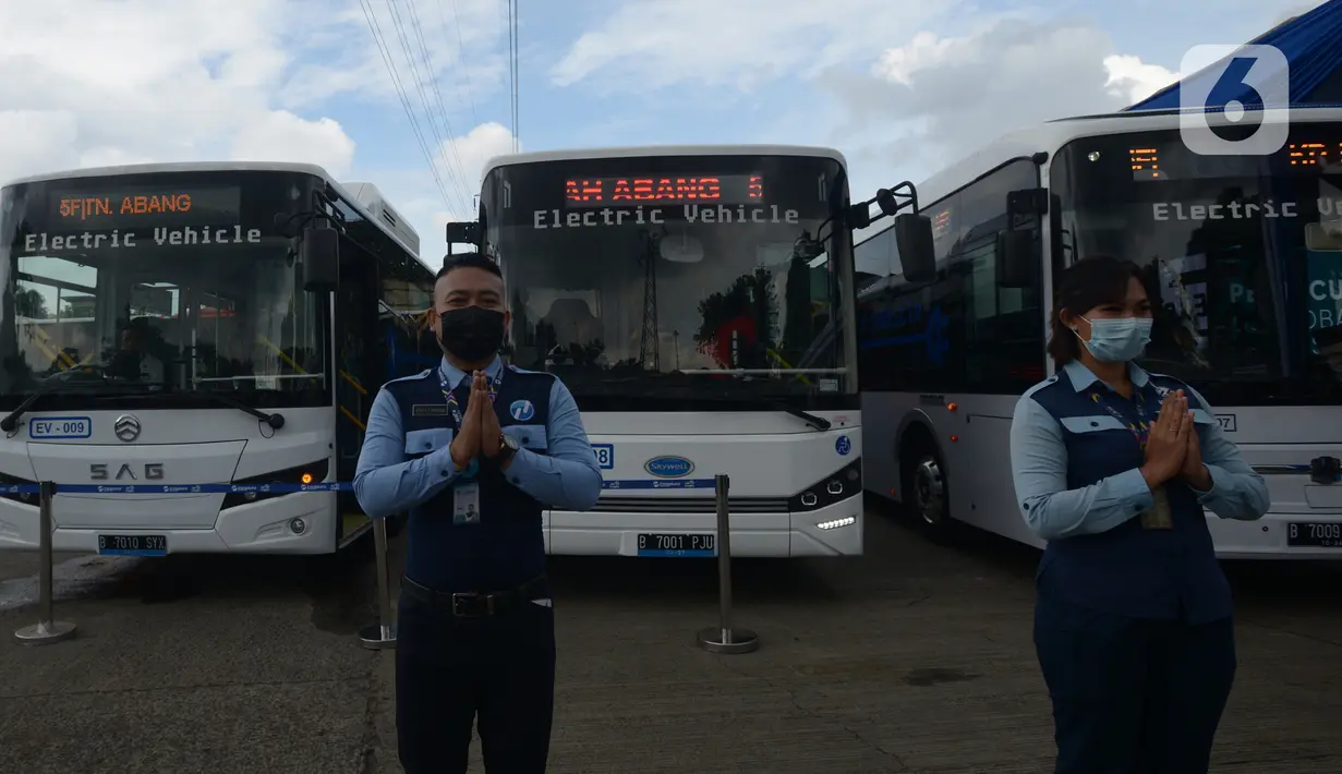 Petugas berdiri di depan bus listrik Transjakarta saat peluncuran uji coba bus tersebut di Pool Transjakarta, Terminal Kampung Rambutan, Jakarta, Rabu (8/6/2022). Bus listrik itu akan melalui rute di jalur non Bus Rapid Transit (BRT) yang belum pernah dilalui bus listrik. (merdeka.com/Imam Buhori)