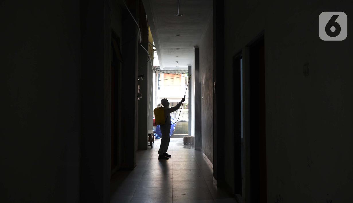 Petugas menyemprotkan cairan disinfektan di ruang kerja dan ruang pelayanan Suku Dinas Sosial Jakarta Timur, Jumat (18/2/2022). Sebanyak 6 orang yang terpapar Covid-19 sedang menjalani isolasi di rumah, sementara pelayanan ditutup selama tiga hari. (merdeka.com/Imam Buhori)