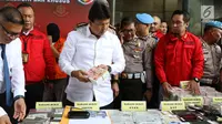 Kabareskrim Komjen Ari Dono memeriksa barang bukti kasus pemalsuan dokumen dan uang palsu dalam rilis di Jakarta, Rabu (20/12). Polisi menangkap 13 tersangka yang mulai beroperasi sejak 2014 di wilayah Jakarta dan Jawa Barat. (Liputan6.com/Angga Yuniar)