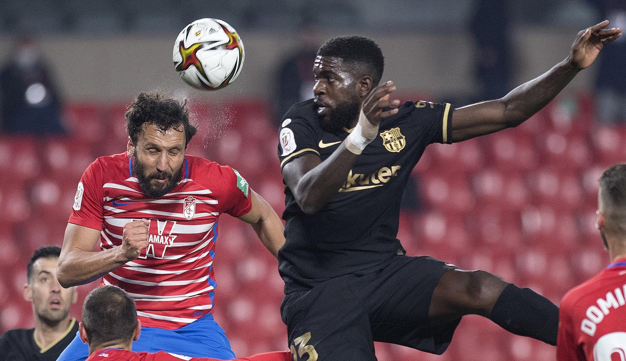 Bek Barcelona, Samuel Umtiti (kanan) berduel udara dengan bek Granada, German Sanchez dalam laga perempatfinal Copa del Rey 2020/21 di Nuevo Los Carmenes Stadium, Rabu (3/2/2021). Barcelona menang 5-3 (2-2) atas Granada melalui babak extra time. (AFP/Jorge Guerrero)