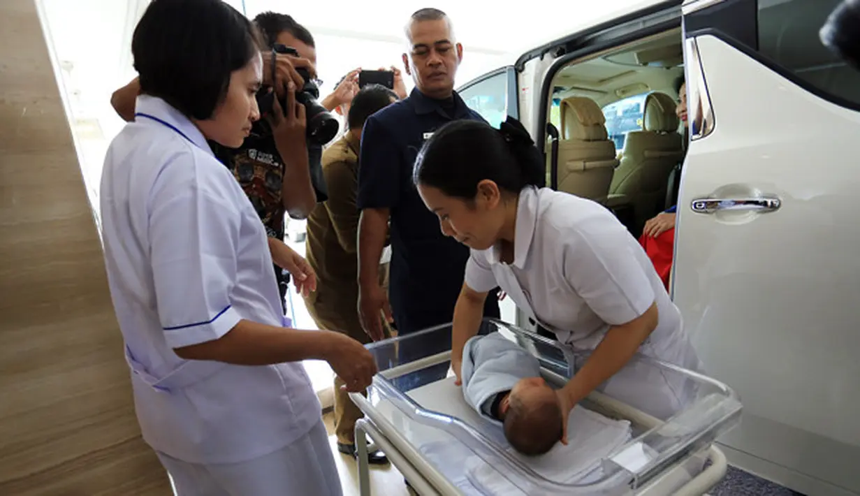 Seorang suster mengakat bayi dari dalam kereta bayi untuk dipindahkan ke dalam mobil saat aka dibawa pulang. Raphael Moeis anak pertamanya pasangan ini lahir melalui proses normal. (Deki Prayoga/Bintang.com)