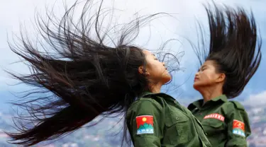 Dua prajurit wanita Tentara Negara Persatuan WA saat menari dalam sebuah acara di Pansang, wilayah pemberontak Wa di Myanmar pada 1 Oktober 2016. Kelompok Wa merupakan pemberontak yang paling kuat di Myanmar. (Reuters/Soe Zeya Tun)