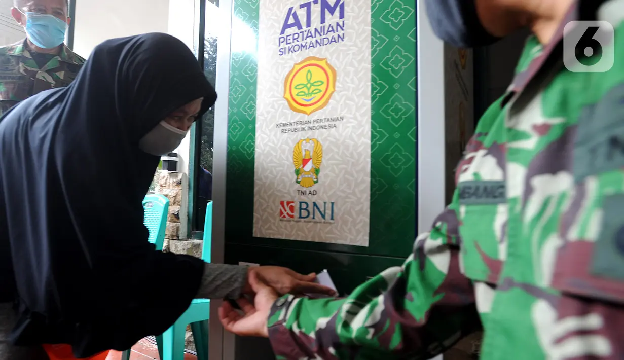 Warga menggunakan ATM Pertanian Si Komandan untuk mendapatkan beras gratis di Kodim 0606/Kota Bogor, Jawa Barat, Minggu (26/4/2020). ATM beras menyediakan 1,5 ton beras per harinya untuk 1000 warga sebagai upaya membantu masyarakat miskin yang terkena dampak Covid-19. (merdeka.com/Arie Basuki)