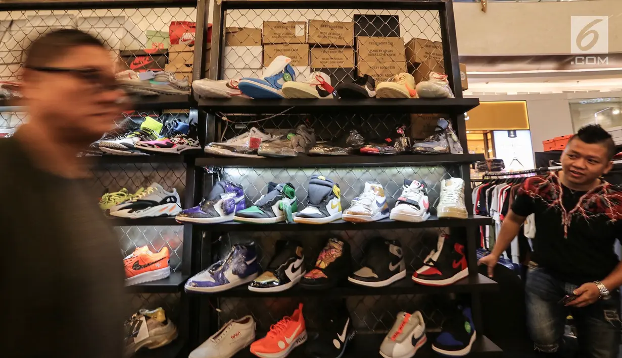 Pengunjung melintas di depan etalase sepatu sneaker pada bazar Sneakerpeak Kemang Quatro di Lippo Mall Kemang, Jakarta, Rabu (20/11). Sneakerpeak Kemang Quatro memberikan inspirasi bagi pecinta dan kolektor sneaker. (Liputan6.com/Fery Pradolo)