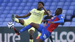 Striker Crystal Palace, Christian Benteke (kanan) berbebut bola dengan gelandang Arsenal, Thomas Partey dalam laga lanjutan Liga Inggris 2020/2021 pekan ke-37 di Selhurst Park, London, Rabu (19/5/2021). Crystal Palace kalah 1-3 dari Arsenal. (AP/Facundo Arrizabalaga/Pool)