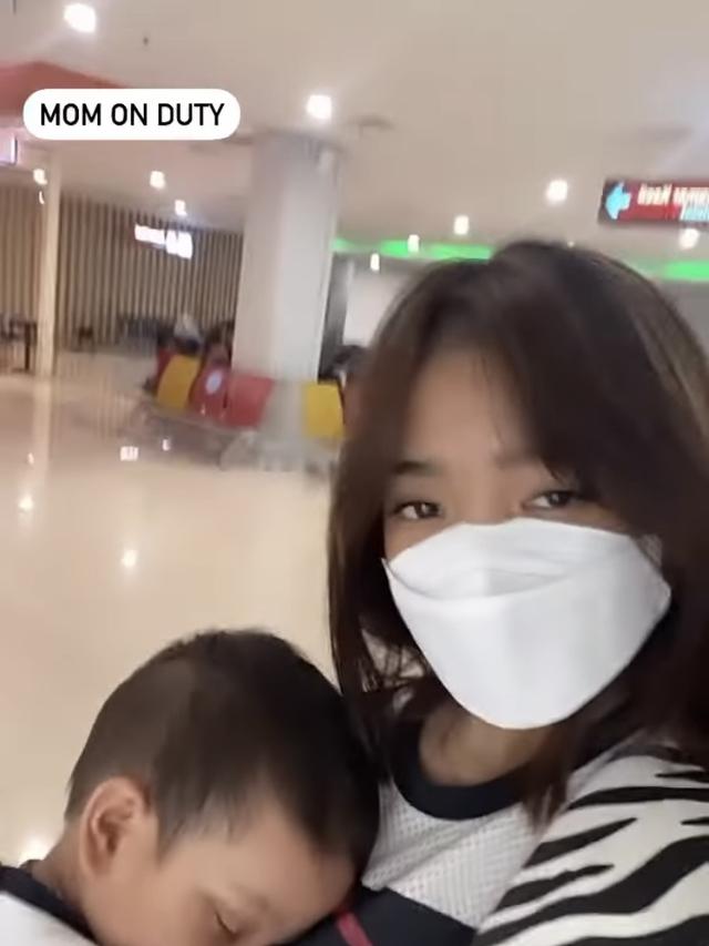 Fuji menggendong sang keponakan, Gala Sky di bandara dalam perjalanan pulang dari Bali ke Jakarta.
