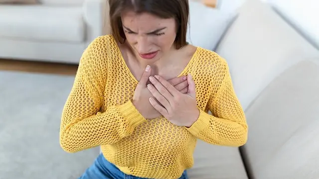 Seorang perempuan berbaju kuning tampak kesakitan dan memegang bagian dadanya (Foto Dok: Freepik/stefamerpik)