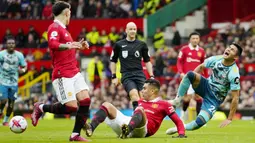 Pemain Manchester United, Casemiro, melakukan pelanggaran kepada pemain Southampton, Carlos Alcaraz pada laga Liga Inggris di Stadion Old Trafford, Minggu (12/3/2023). (AP Photo/Jon Super)