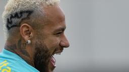Penyerang Brasil, Neymar tertawa saat mengikuti sesi latihan tim di Sao Paulo, Brasil, Rabu (10/11/2021). Neymar memamerkan aksesori mencolok terbarunya  dengan membuat tato Batman di kepalanya. (AP Photo/Andre Penner)
