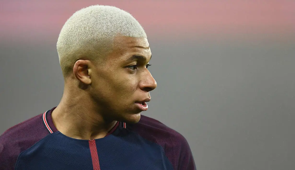 Penyerang PSG, Kylian Mbappe saat bertanding melawan Caen pada lanjutan pertandingan Ligue 1 di Stadion Raymond-Kopa, di Angers, Prancis (20/12). Dengan rambut dicat warna putih MBappe mencetak satu gol di pertandingan tersebut. (AFP Photo/Franck Fife)