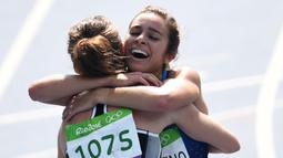 Abbey D'agostino memeluk Nikki Hamblin usai finis pada ajang lari 5000m putri Olimpiade Rio 2016 di Olympic Stadium, Rio de Janeiro, (16/8/2016). (AFP/Pedro Ugarte)