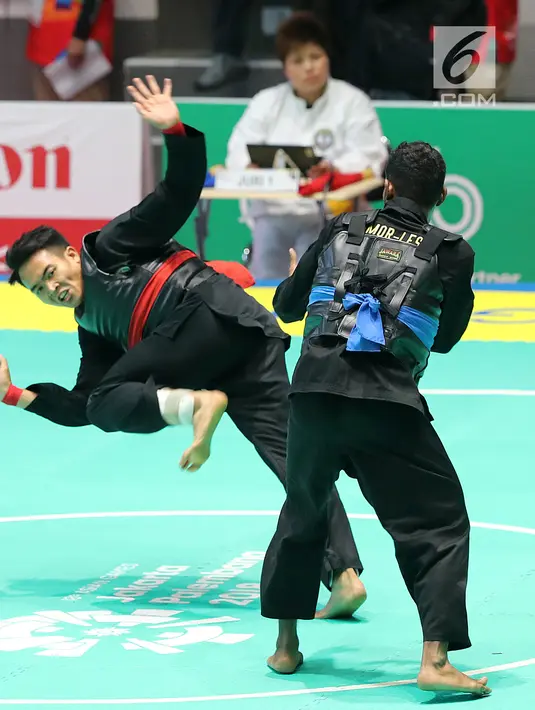 Pesilat Indonesia, Komang Harik Adiputra (kiri) beradu jurus dengan pesilat Timor Leste, David No-Ano Ximenes dalam kelas 65-70 kg Putra Asian Games 2018 di Padepokan Pencak Silat TMII, Jakarta, Kamis (23/8). Komang unggul 5-0. (Liputan6.com/Fery Pradolo)