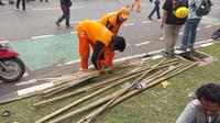 Pasukan orange terlihat di sekitaran Gedung DPR membersihkan bambu sisa-sisa tiang bendera. (Foto: Liputan6.com/Liputan6.com/Arief RH)