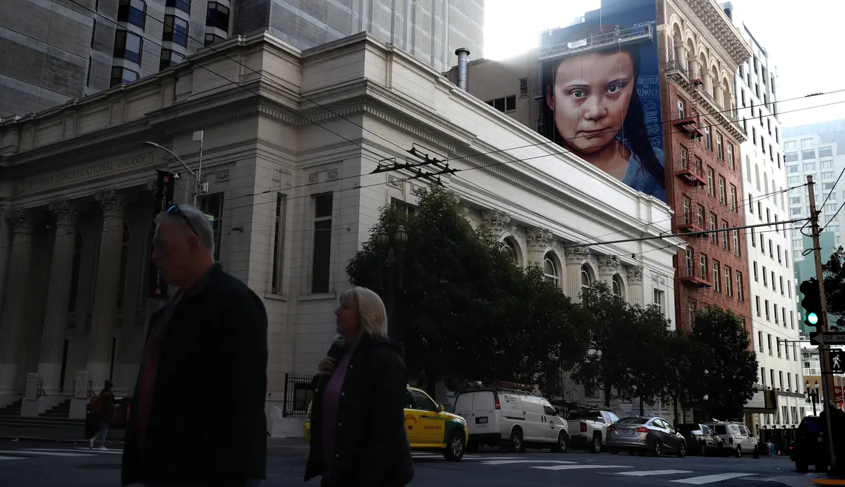 Pemandangan mural dengan gambar aktivis perubahan iklim Greta Thunberg asal Swedia di sebuah gedung di pusat Kota San Francisco, California, 11 November 2019. Mural setinggi 18 meter dan lebar 9 meter itu dibuat seniman jalanan asal Argentina, Andres Petreselli. (Justin Sullivan/Getty Images/AFP)