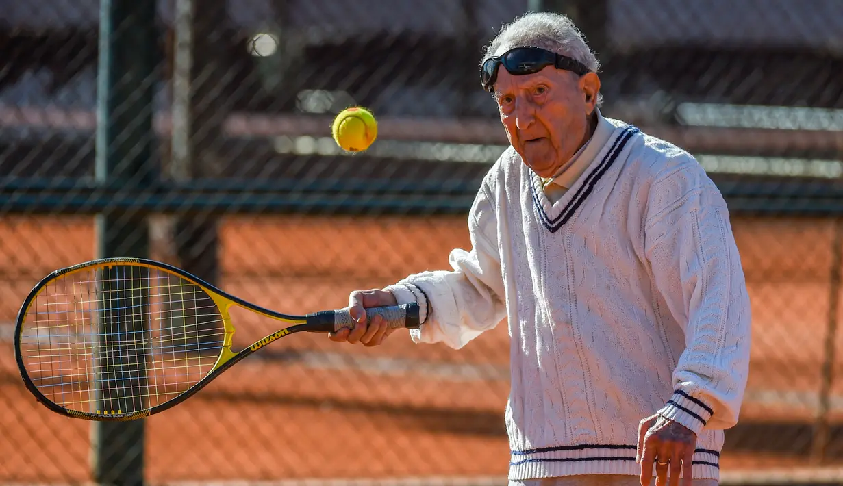 Artyn Elmayan, seorang pria asal Armenia, bermain tenis di River Plate Club di Buenos Aires, Selasa (16/5). Meski usianya telah mencapai 100 tahun, Artyn mengaku tetap rutin main tenis tiga kali seminggu. (AFP FOTO / Eitan ABRAMOVICH)