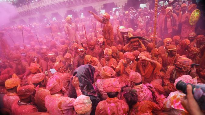 Umat Hindu merayakan Holi, festival warna musim semi, di sebuah kuil di desa Nandgaon, negara bagian Uttar Pradesh, 5 Maret 2020. Festival Holi diselenggarakan pada awal musim semi yaitu pada akhir Februari hingga Maret, tepatnya sesudah bulan purnama. (Money SHARMA/AFP)