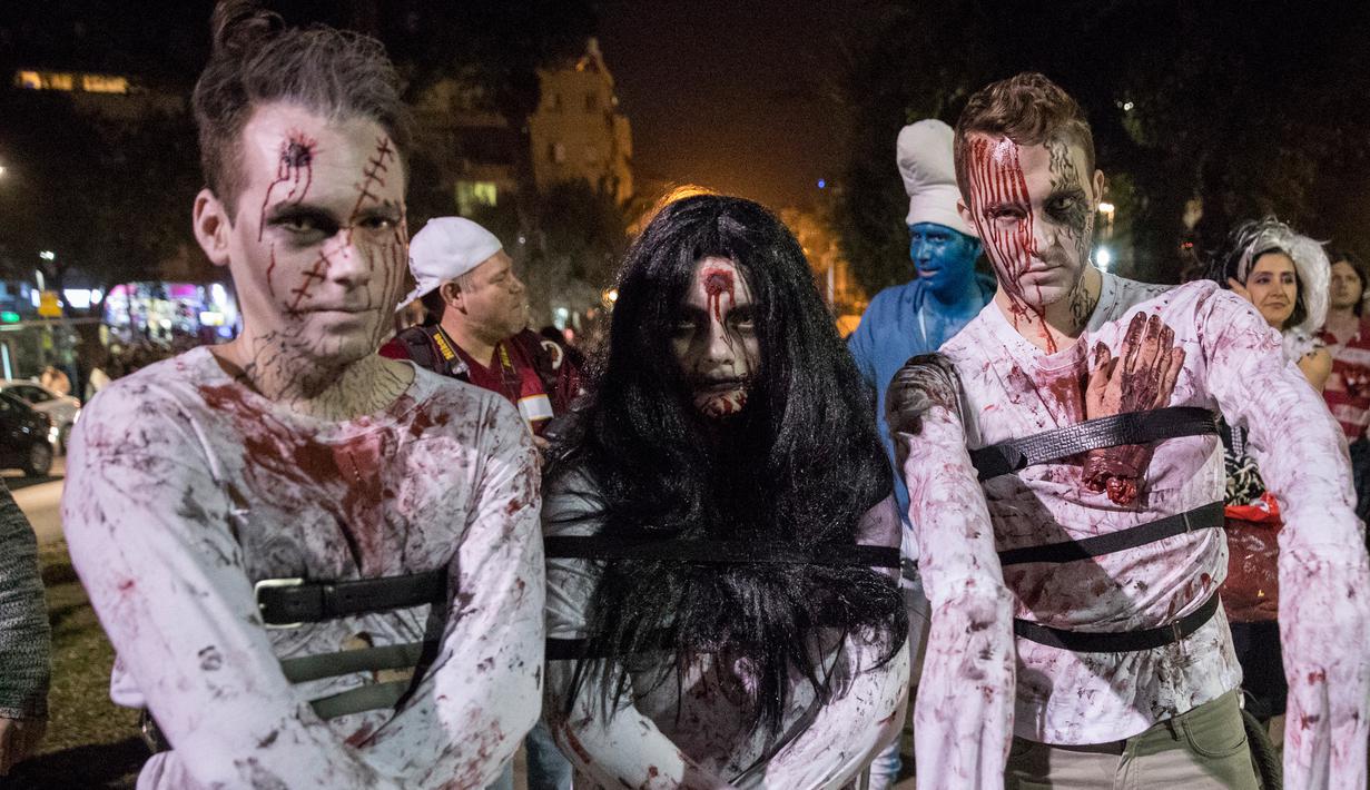 Sejumlah peserta mengenakan kostum menyerupai zombie saat merayakan hari Purim di Tel Aviv (11/3). Purim merupakan hari raya atau pesta Yahudi untuk memperingati pembebasan kaum Yahudi dari kekaisaran Persia. (AFP/Jack Guez)